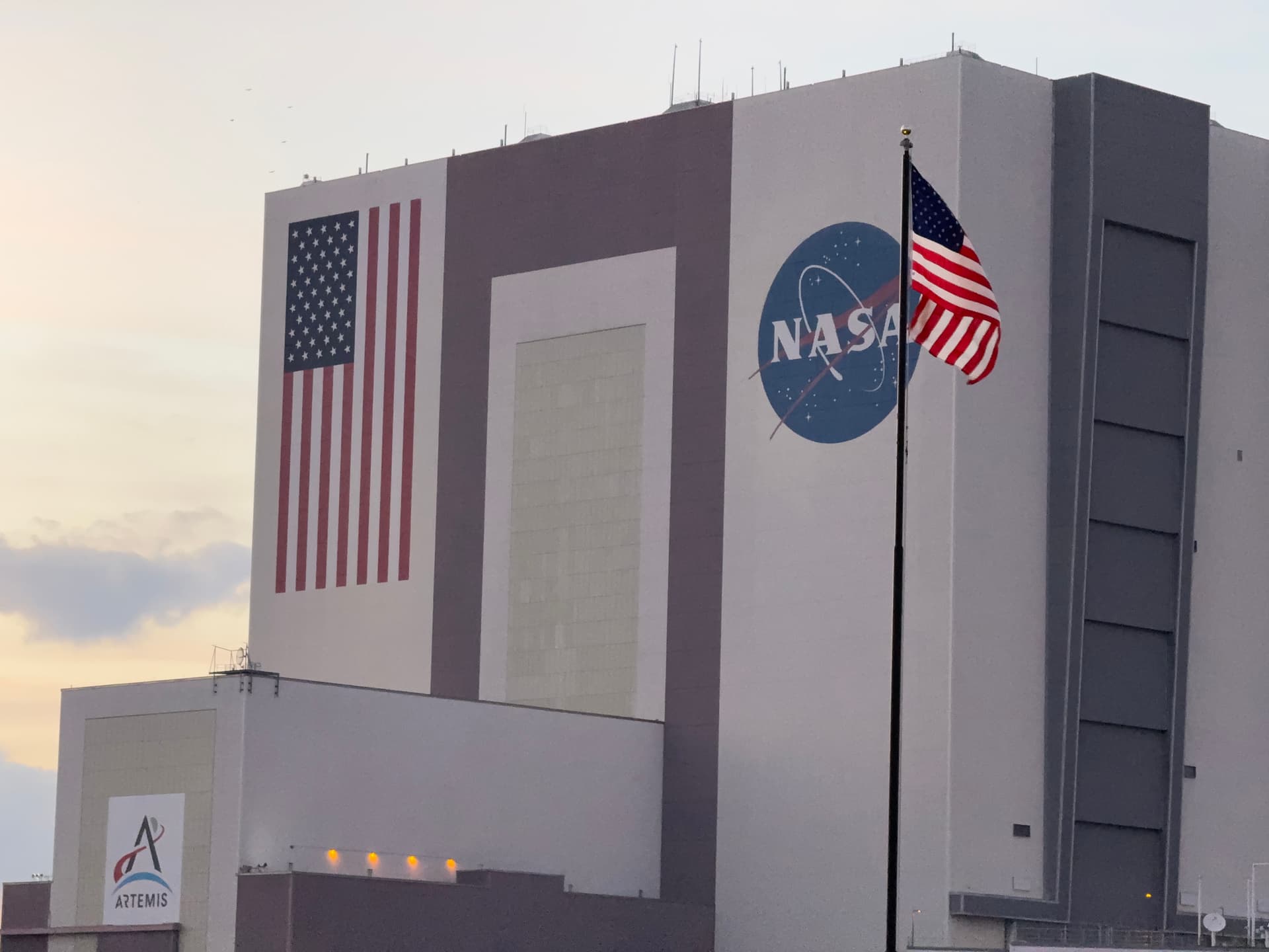 An American flag flies in front of NASA’s Vehicle Assembly Building at Kennedy Space Center, Fla., on Feb. 19, 2026. (T.J. Muscaro/The Epoch Times)