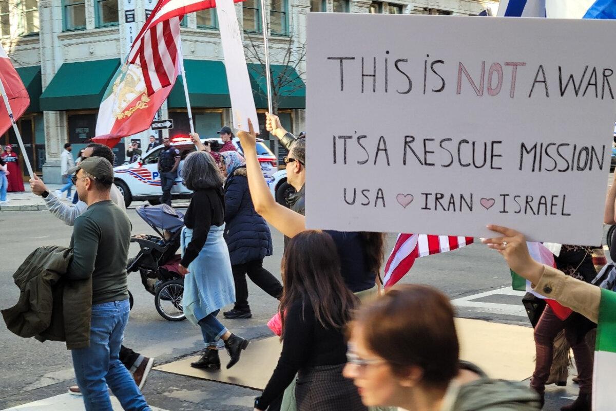 People supporting the joint U.S.–Israeli military strikes against Iran wave banners and signs during a march from the World War I Memorial toward the White House on Feb. 28, 2026. (Stacy Robinson/The Epoch Times)