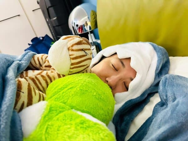 Dr. Lin Shao-Chen, neurologist and director of Pin Xin Clinic in Taichung, Taiwan, sleeps inside her shark sleeping bag, with her face peeking out from the shark’s mouth. (Courtesy of Lin Shao-Chen)