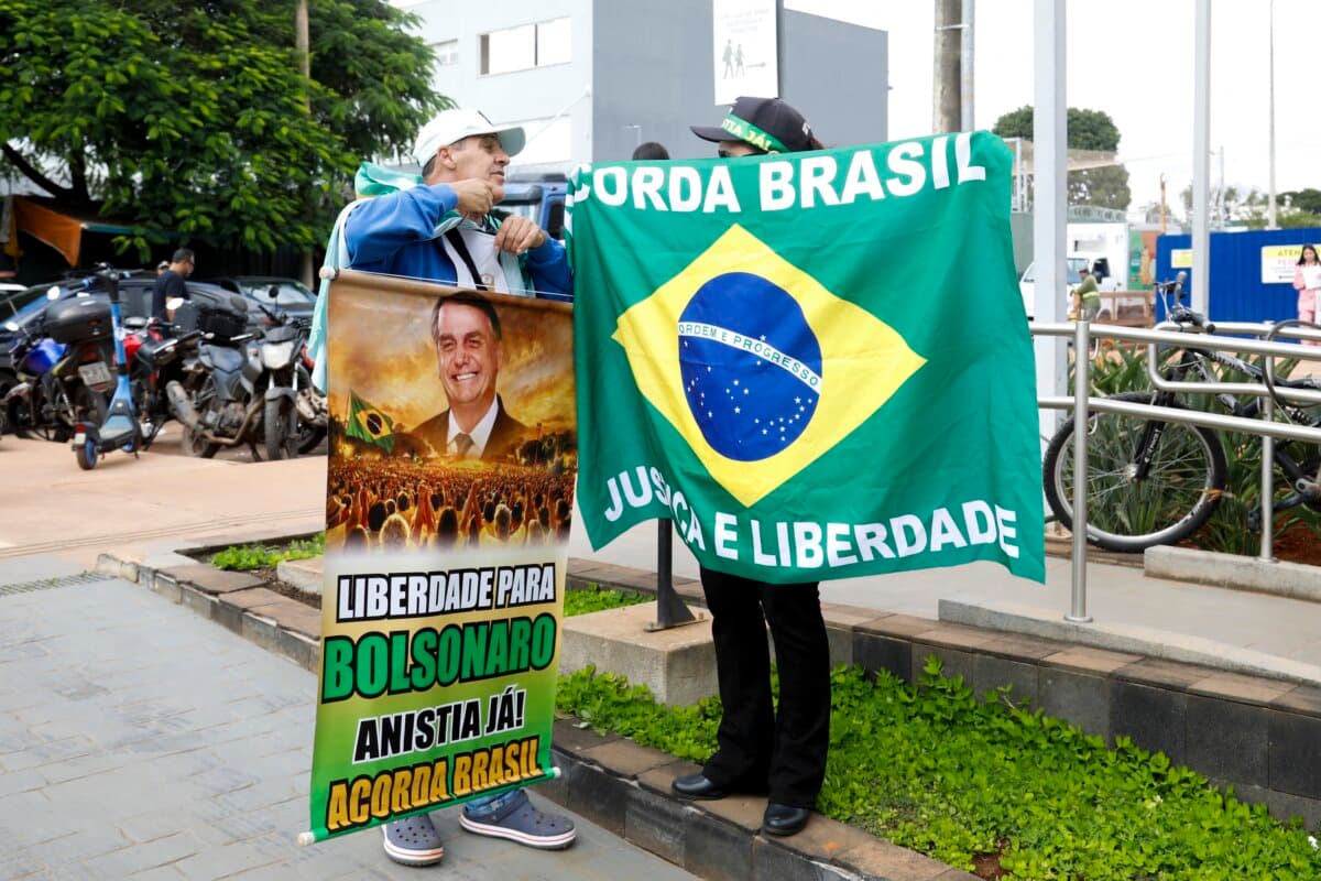Supporters of former Brazilian President Jair Bolsonaro wait for him to be discharged from DF Star hospital in Brasilia with a sign reading "Freedom for Bolsonaro. Amnesty now! Wake up Brazil" on March 27, 2026. (Sergio Lima/AFP)