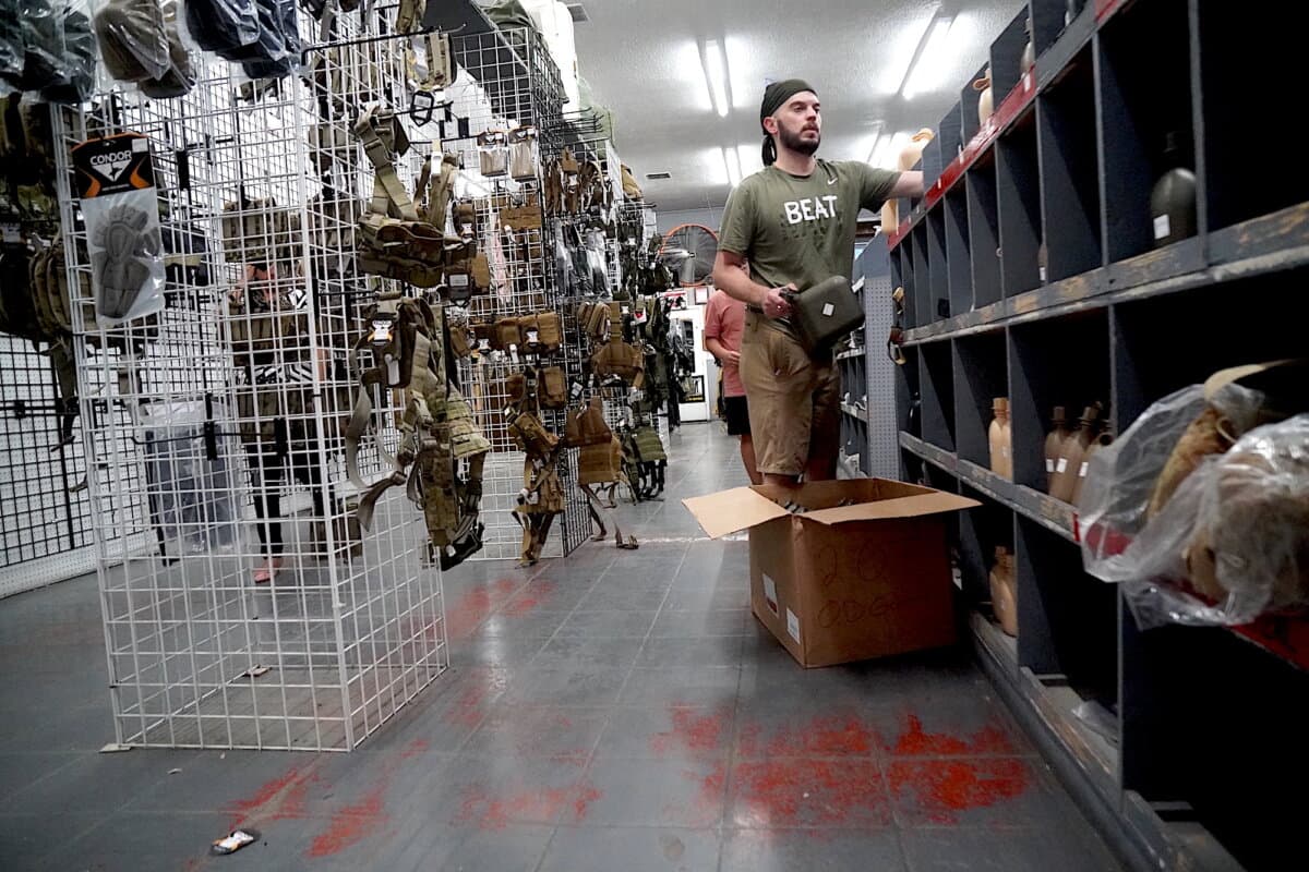 Andrew Thompson, an employee at Miller's Surplus, stocks a shelf during a business liquidation sale in Tucson, Ariz., on April 4, 2026. (Allan Stein/The Epoch Times)