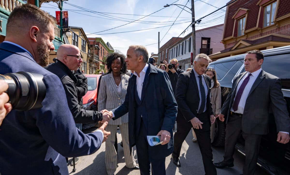 Prime Minister Mark Carney and Liberal candidate Tatiana Auguste greet people as they campaign in her riding in Terrebonne, Que., on April 9, 2026. (The Canadian Press/Christinne Muschi)