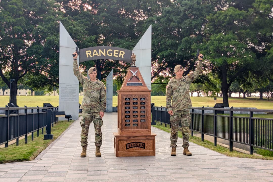 Spc. Caleb Godbold (L) and Sgt. Drew Schorsch raise custom Staccato P4X pistols in front of the National Ranger Memorial at Fort Benning, Ga., on April 13, 2026. The two-man team, representing the 75th Ranger Regiment, received the pistols after winning the 2026 Best Ranger Competition. (Ryan Morgan/The Epoch Times)