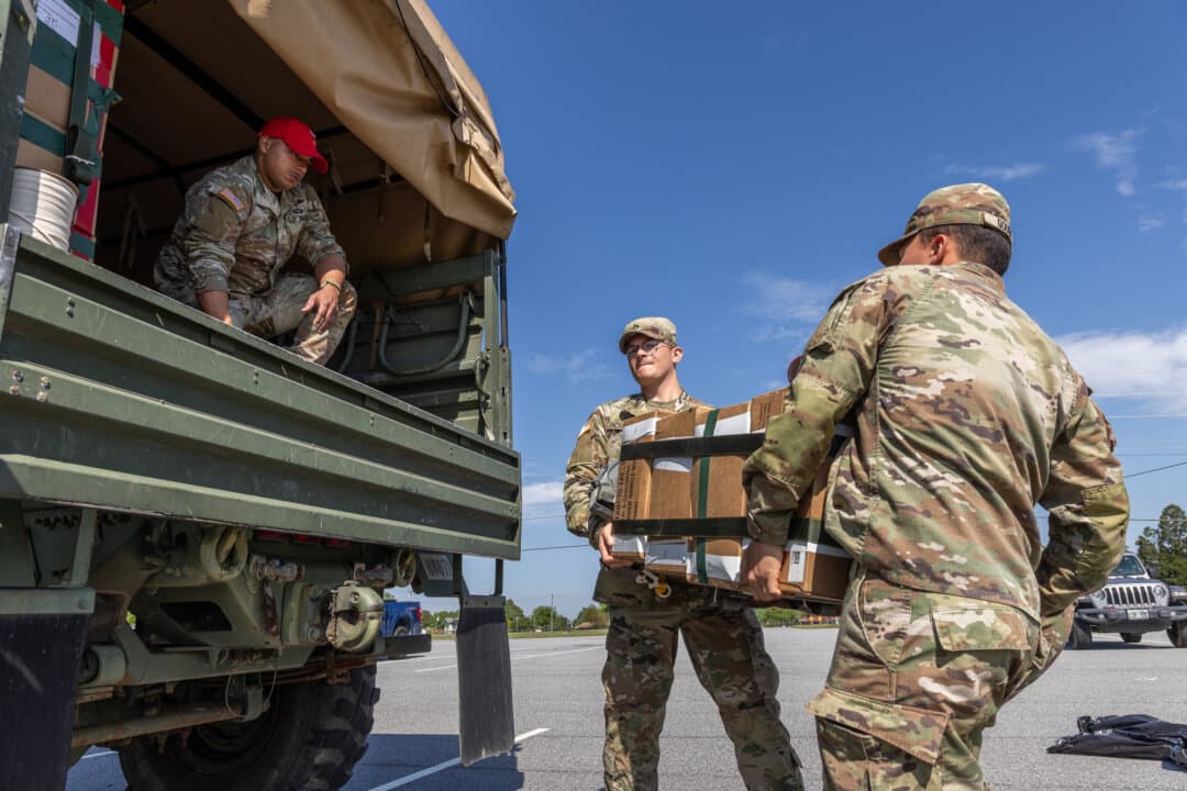 Soldiers of the United States Army load military equipment into a vehicle at Fort Benning, Ga., on April 8, 2026. (John Fredricks/The Epoch Times)