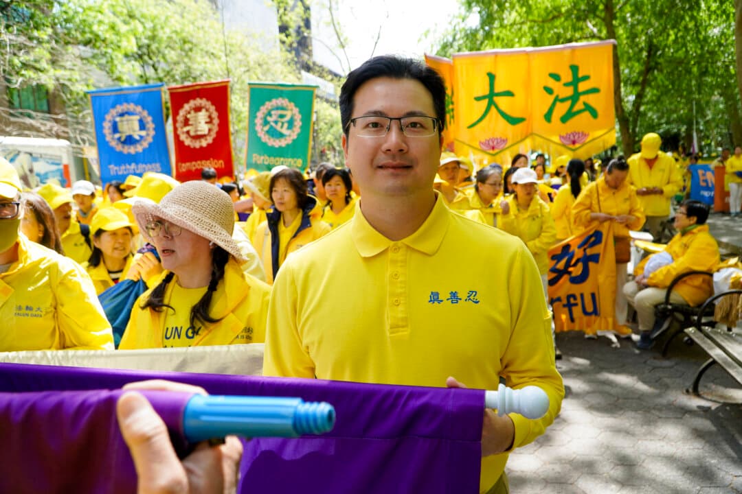 Hugh Huang, 34, originally from Hong Kong, Huang said practicing Falun Gong has helped him handle his anger better. He and other adherents of the practice lined up in Dag Hammarskjöld Plaza, to prepare for a parade celebrating World Falun Dafa Day, May 13, 2026. (Nicholas Zifcak/The Epoch Times)