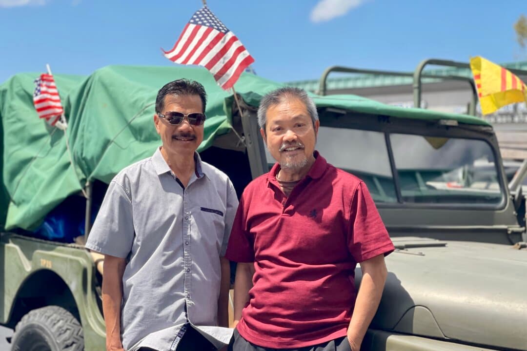 Sy Nguyen (L) and David Pham stand next to an antique de-comissioned U.S. Army Jeep flying American and South Vietnamese flags near Pham's Little Saigon business in Westminster, Calif., on May 27, 2026. Pham told The Epoch Times his vote would go to a Republican, but he hadn’t yet decided which one. (Beige Luciano-Adams/The Epoch Times)