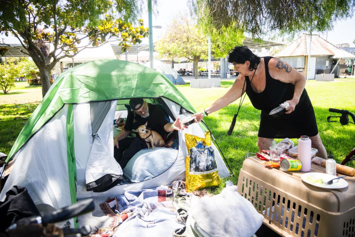 Jan De Jonge and fiancé Sher Stuckman set up a tent with their belonging and pet outside the Elks Lodge in Garden Grove, Calif., on May 25, 2026. (AP Photo/Ethan Swope)