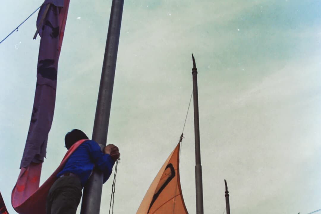 (Left) Pro-democracy protesters climb atop a flagpole to put up banners in Beijing in the spring of 1989. (Middle) A man sleeps in front of a bus, where lines of verse encourage people to join the pro-democracy protests in Beijing in the spring of 1989. (Right) Pro-democracy protesters in Tiananmen Square in Beijing in the spring of 1989. (Provided to The Epoch Times)