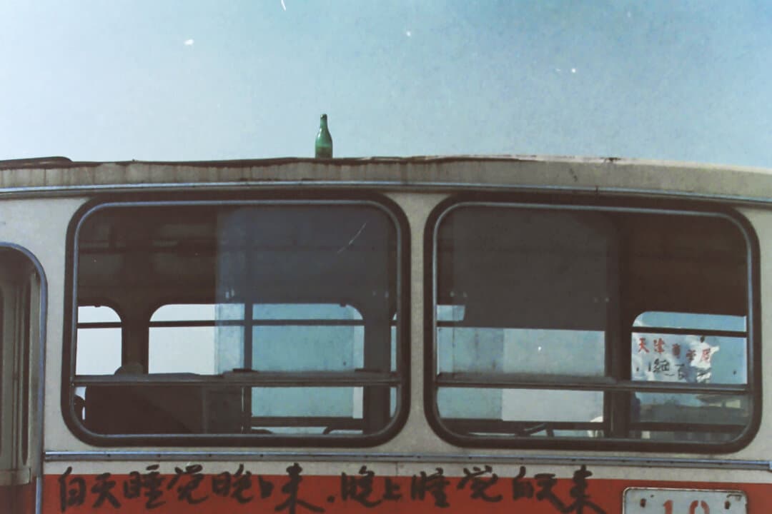 (Left) Pro-democracy protesters climb atop a flagpole to put up banners in Beijing in the spring of 1989. (Middle) A man sleeps in front of a bus, where lines of verse encourage people to join the pro-democracy protests in Beijing in the spring of 1989. (Right) Pro-democracy protesters in Tiananmen Square in Beijing in the spring of 1989. (Provided to The Epoch Times)