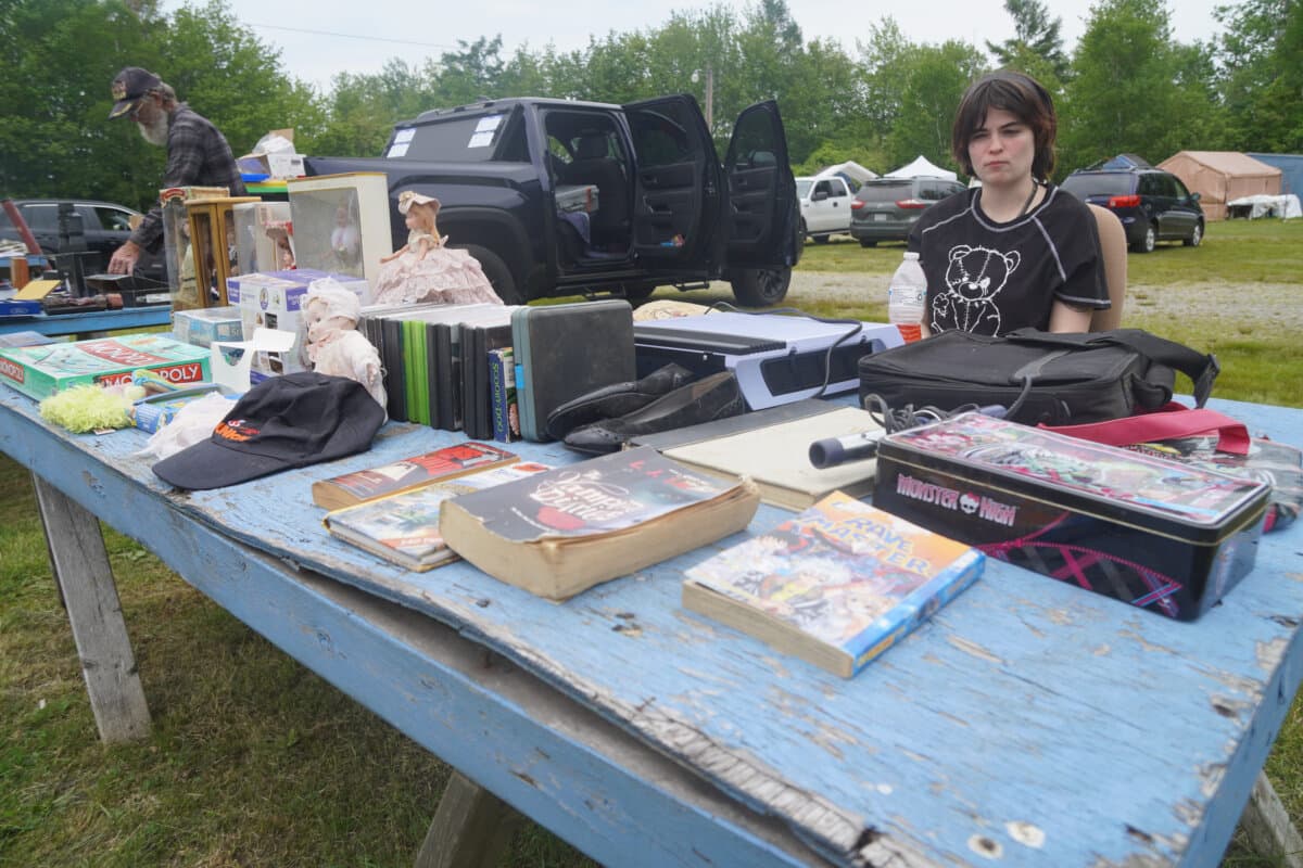 Kate Johnson sells items at a flea market in Searsport, Maine, on June 6, 2026. (Nathan Worcester/The Epoch Times)