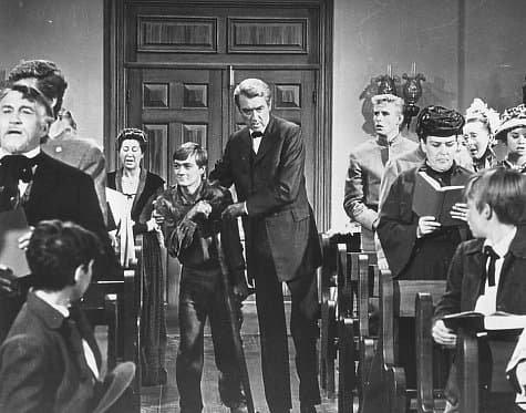 Boy (Philip Alford, L) and Charlie Anderson (James Stewart) attend church services, in "Shenandoah." (Universal Pictures)
