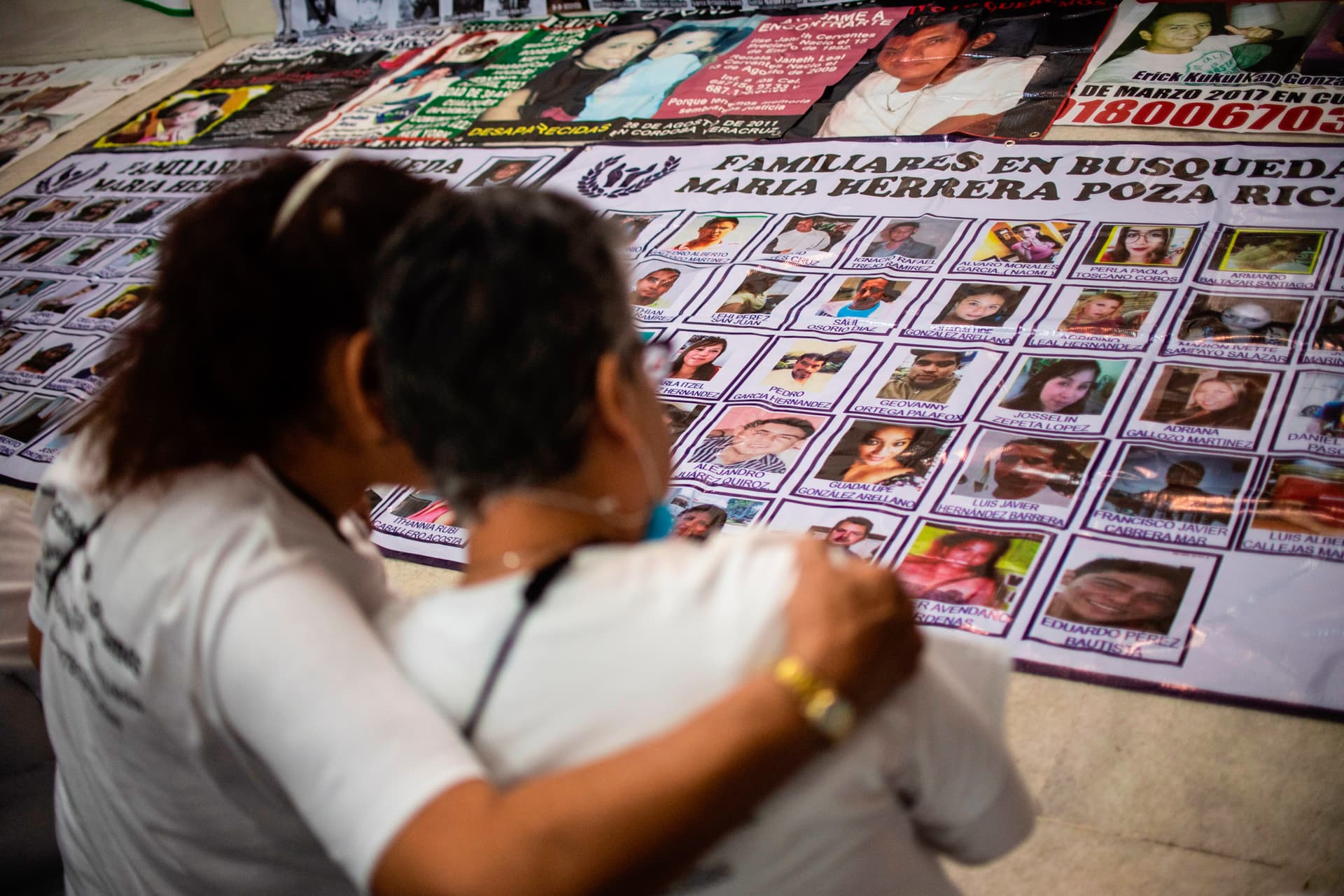 Women view portraits of missing people in Huitzuco de los Figueroa, Mexico, on Jan. 20, 2019.(Pedro Pardo/AFP via Getty Images)