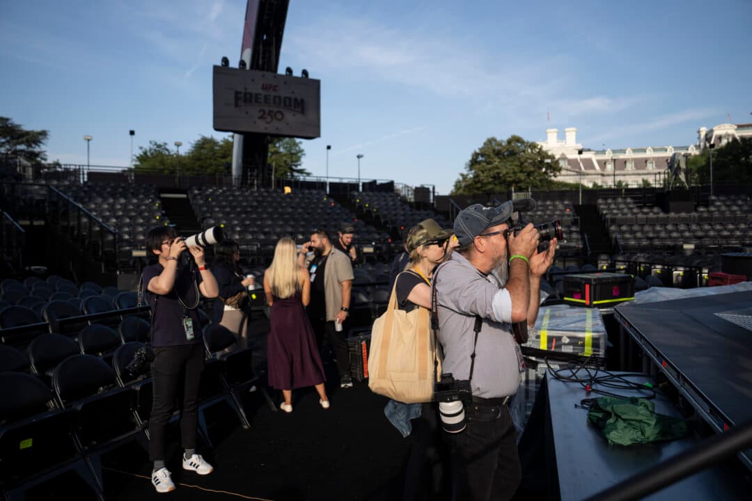 Still photographers take photos of the UFC cage at the White House on June 11, 2026. (Madalina Kilroy/The Epoch Times)