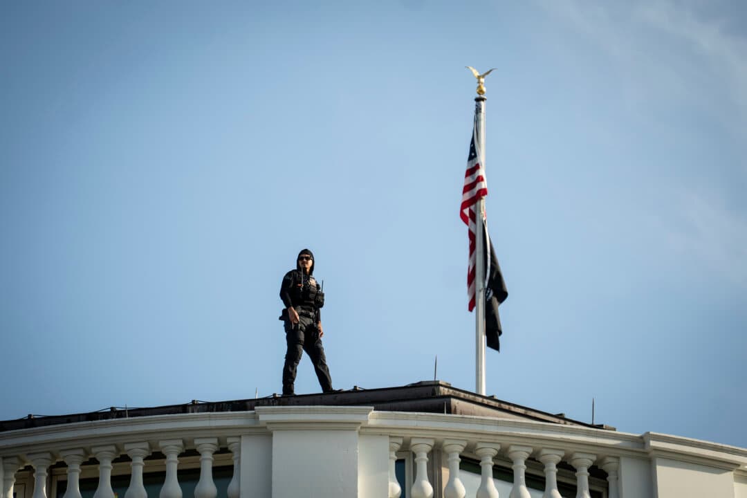 A U.S. Secret Service agent looks out from the White House rooftop on June 11, 2026. (Madalina Kilroy/The Epoch Times)