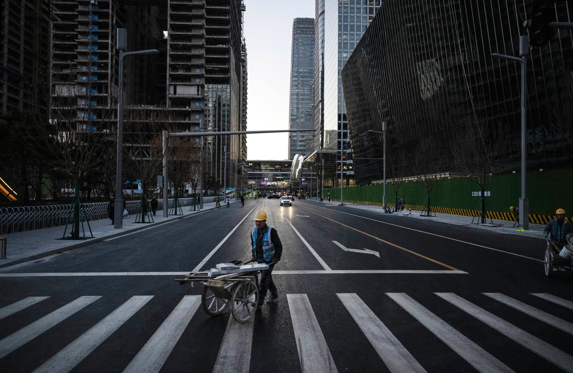 A construction worker pushes a wheelbarrow with materials across the road in the central business district in Beijing, China, on Nov. 29, 2024. (Kevin Frayer/Getty Images)