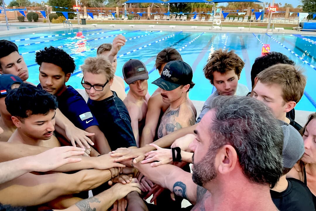 Deep End Fitness Scottsdale trainees take part in a team huddle during a pool session in Scottsdale, Ariz., on May 21, 2026. Instructors say trainees gain not only physical stamina and better focus, but confidence as well. (Allan Stein/The Epoch Times)