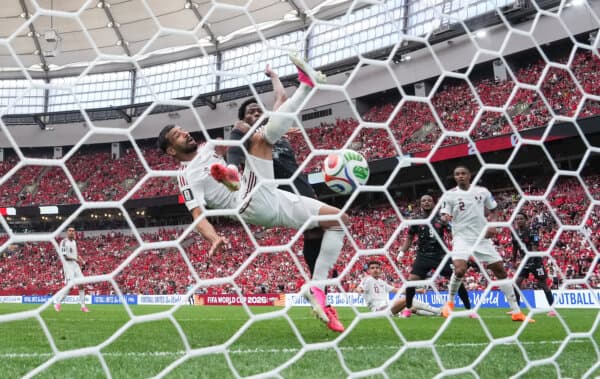 Canada's Jonathan David (back) scores past Qatar's Boualem Khoukhi during the first half of a World Cup Group B soccer match, in Vancouver on June 18, 2026. (The Canadian Press/Darryl Dyck)