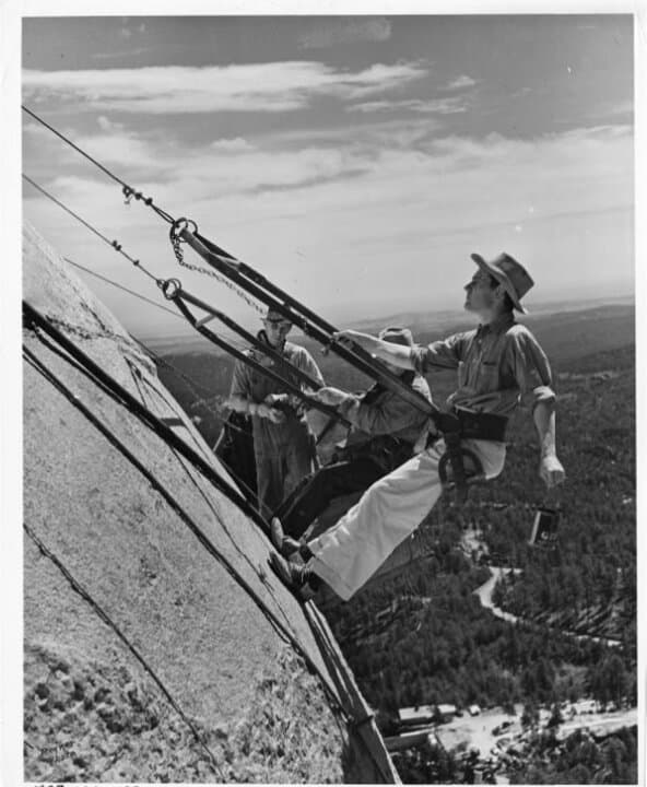 (Top Left) Gutzon Borglum and his crew work on the face of Abraham Lincoln near Keystone, S.D., in this file photo. Borglum originally intended the sculptures to include the presidents' torsos. (Top Right) Borglum and site manager Jesse Tucker during Mount Rushmore construction, near Keystone, S.D., in this file photo. (Bottom Left) Sculptor Gutzon Borglum and his son, Lincoln Borglum, on Mount Rushmore, in this file photo. Lincoln Borglum oversaw the completion of Mount Rushmore after his father's death. (Bottom Right) Gutzon Borglum provides guidance to workers on the Mount Rushmore project, near Keystone, S.D., in this file photo. (Courtesy of South Dakota Historical Society)