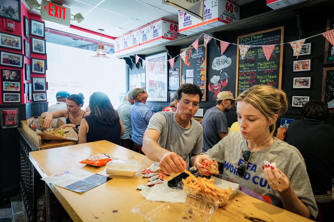 World Cup fans taste local fare at Pauli's sandwich shop in the North End of Boston on June 24, 2026. The diner is known for its overstuffed sandwiches and lobster rolls. (Martin Meissner/AP)