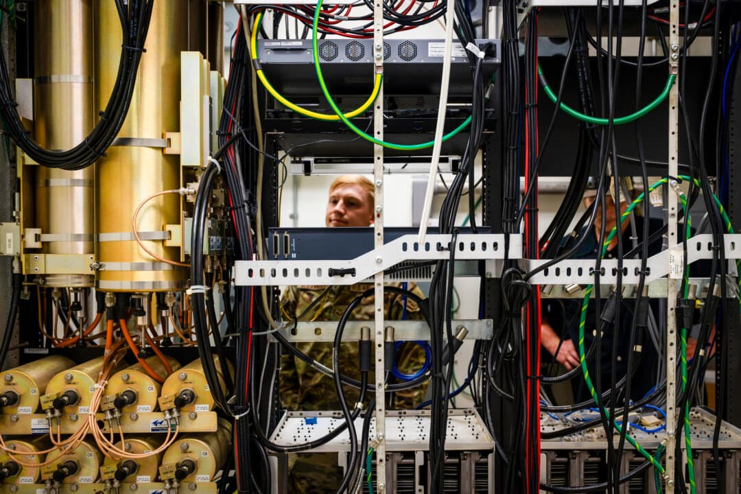 A U.S. Air Force airman checks wiring and system operations in an electronics closet near a transmission tower at Joint Base Charleston in Charleston, S.C., on June 13, 2025. A cybersecurity analyst says he is skeptical that AI models could gain entry from the outside into classified government systems such as those used by the military. (Airman 1st Class Adriana Jordan-Alcañiz/U.S. Air Force)