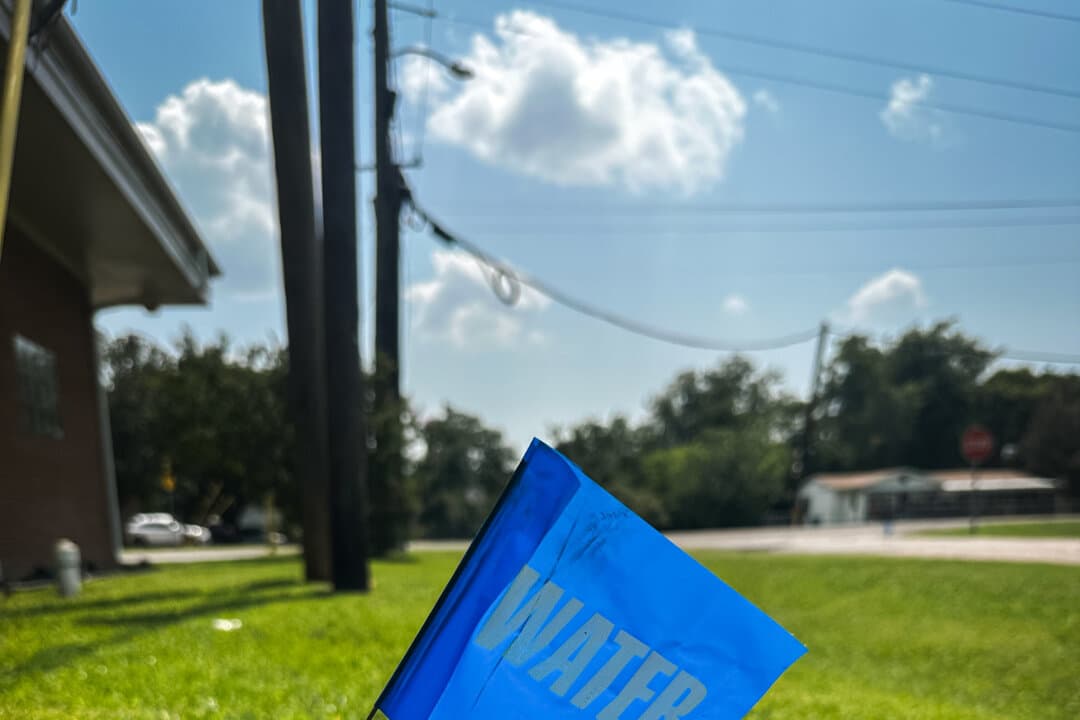 A flag marks the location of a water line near the Trinidad water tower in Trinidad, Texas, on June 22, 2026. Residents of the tiny town said they have been drinking bottled water for years rather than the town's tap water. (Darlene McCormick Sanchez/The Epoch Times)