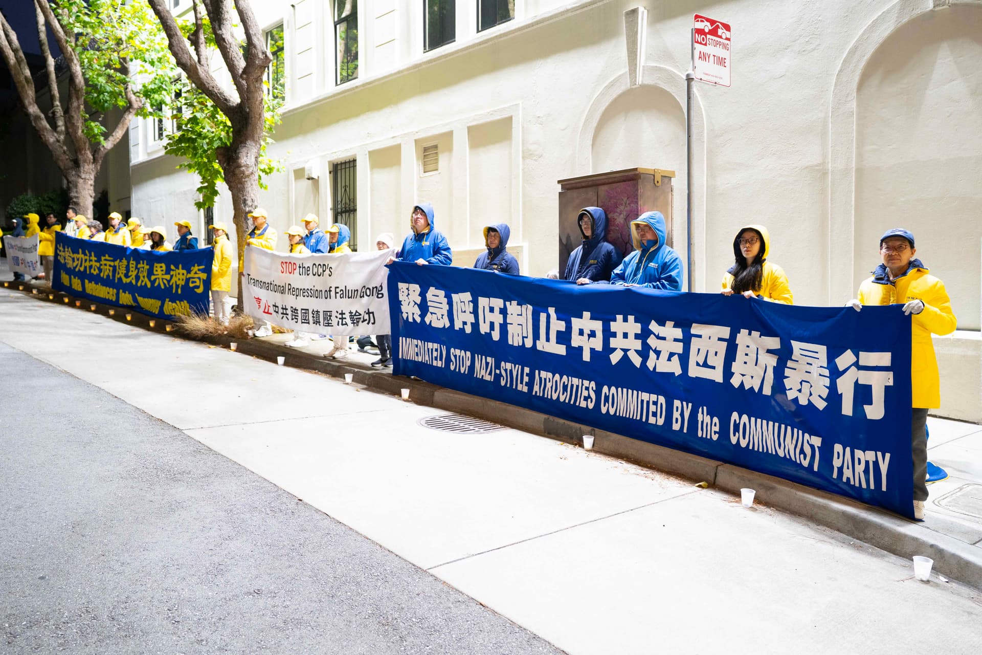 The banners held by Falun Gong practitioners were well lit by floodlights positioned at the top of the Chinese Consulate building on July 19, 2026. (Gary Wang/Epoch Times)