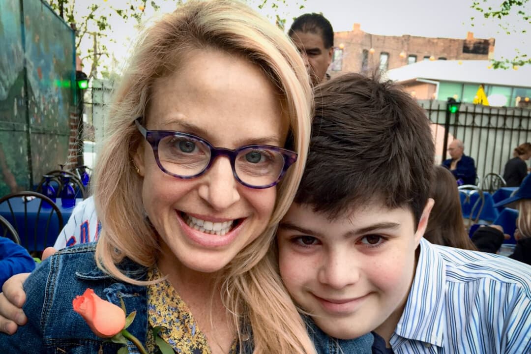 (Left) Laura Berman and her son Sammy, who died at age 16 after taking a fentanyl-laced pill he purchased on Snapchat, pose in this file image. (Right) Laura Berman (L) carries a photo of her son as she protests with family and friends of people who died after being poisoned by pills containing fentanyl, near the Snap, Inc. headquarters in Santa Monica, Calif., on June 4, 2021. (Courtesy of Samuel Chapman, Patrick T. Fallon/AFP via Getty Images)