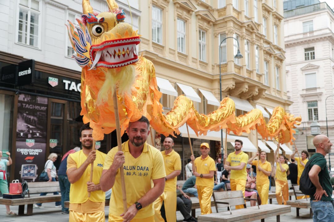 Falun Dafa practitioners handle a Chinese dragon while they participate in a parade in Vienna on Aug. 29, 2026. (Mihut Savu/The Epoch Times)