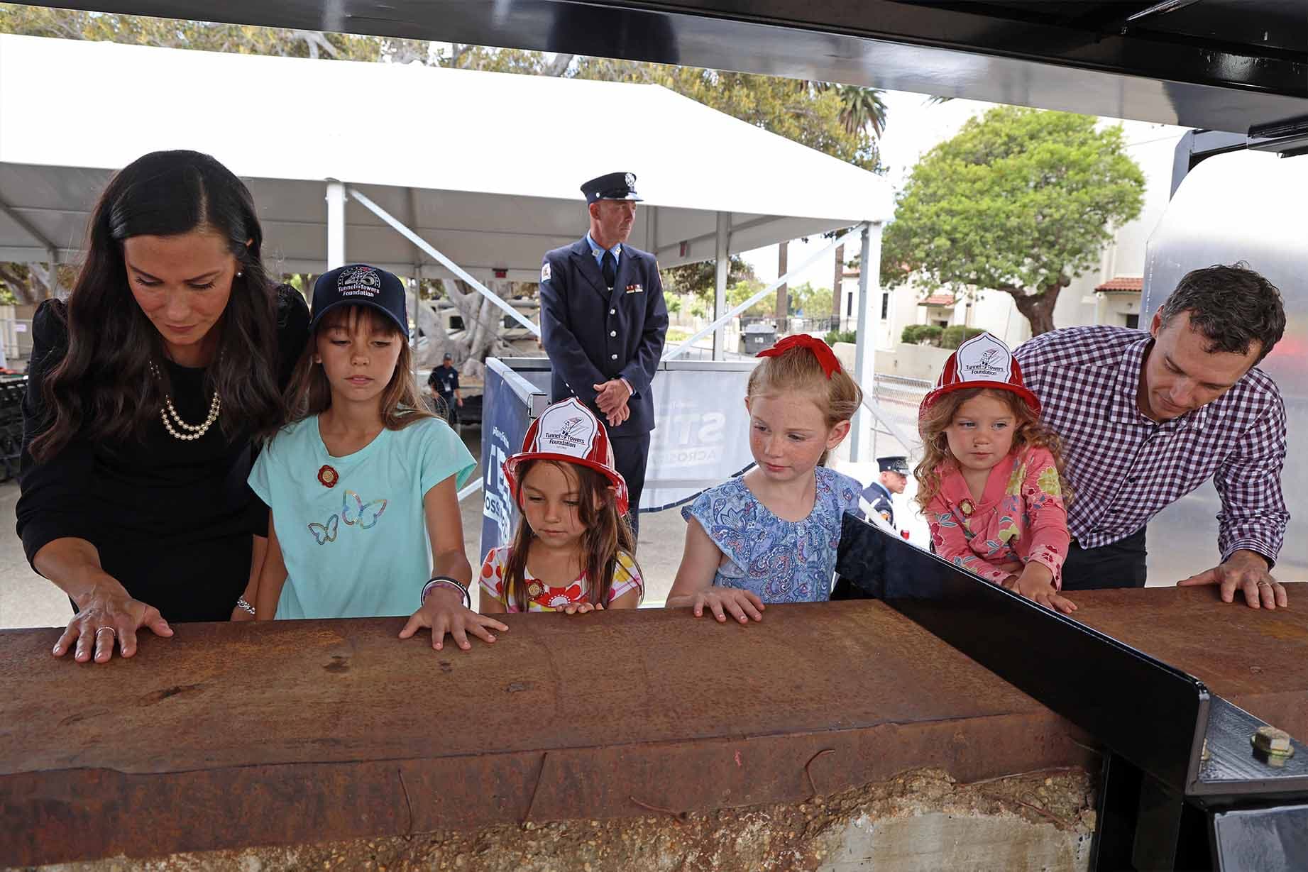 A family pay their respects to the service members who died in the 9/11 attacks. (Tunnel to Towers)