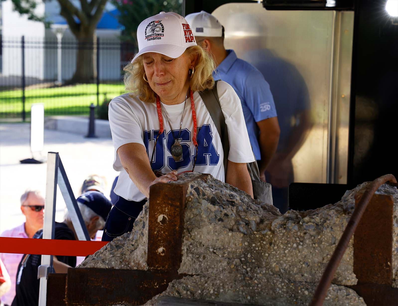 A visitor prays with her hand on the I-beam at the Space Center in Houston. (Tunnel to Towers)