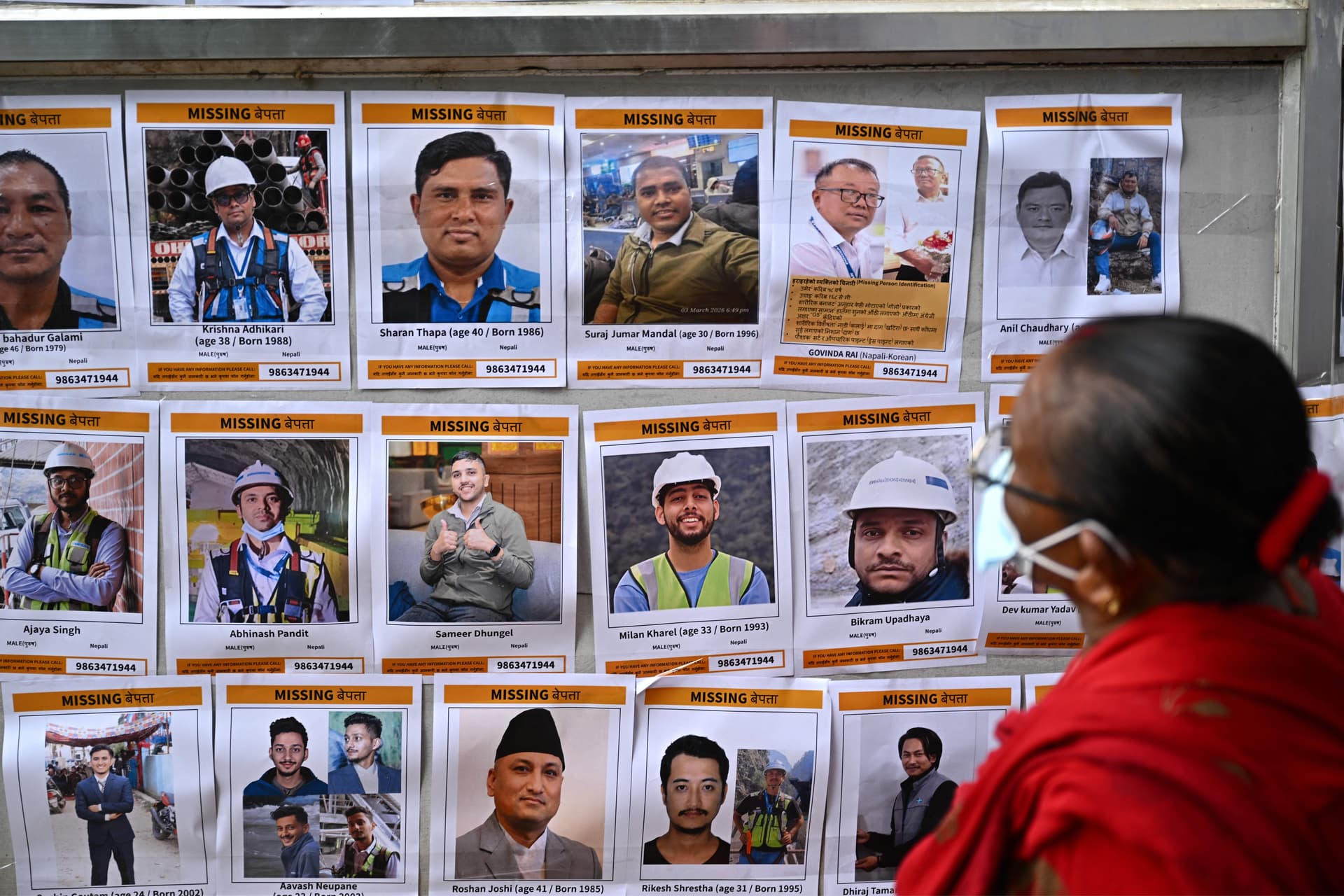 A woman looks at photographs of missing flash flood victims outside a temporary relief camp in Trishuli, Nepal's Nuwakot district, on Sept. 4, 2026. (Pedro Pardo/AFP)