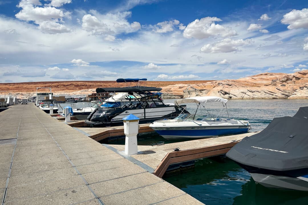 (Top Left) A rental representative (L) helps a customer rent a Ski-Doo at the Antelope Point Marina on Lake Powell, near Page, Ariz., on Aug. 27, 2026. (Top Right) Power boaters on Lake Powell, near Page, Ariz., on Aug. 27, 2026. Boating remains a popular activity at Lake Powell despite historic low water levels. (Bottom Left) Kayakers on Lake Powell at the Antelope Canyon area near Page, Ariz., on July 28, 2026. (Bottom Right) Boats dock at the Antelope Point Marina on Lake Powell, near Page, Ariz., on July 28, 2026. (Allan Stein/The Epoch Times, Luyi Liu/The Epoch Times)