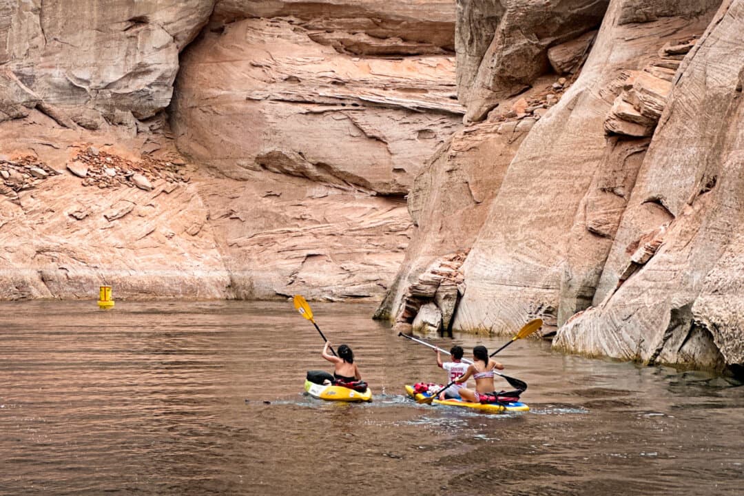 (Top Left) A rental representative (L) helps a customer rent a Ski-Doo at the Antelope Point Marina on Lake Powell, near Page, Ariz., on Aug. 27, 2026. (Top Right) Power boaters on Lake Powell, near Page, Ariz., on Aug. 27, 2026. Boating remains a popular activity at Lake Powell despite historic low water levels. (Bottom Left) Kayakers on Lake Powell at the Antelope Canyon area near Page, Ariz., on July 28, 2026. (Bottom Right) Boats dock at the Antelope Point Marina on Lake Powell, near Page, Ariz., on July 28, 2026. (Allan Stein/The Epoch Times, Luyi Liu/The Epoch Times)