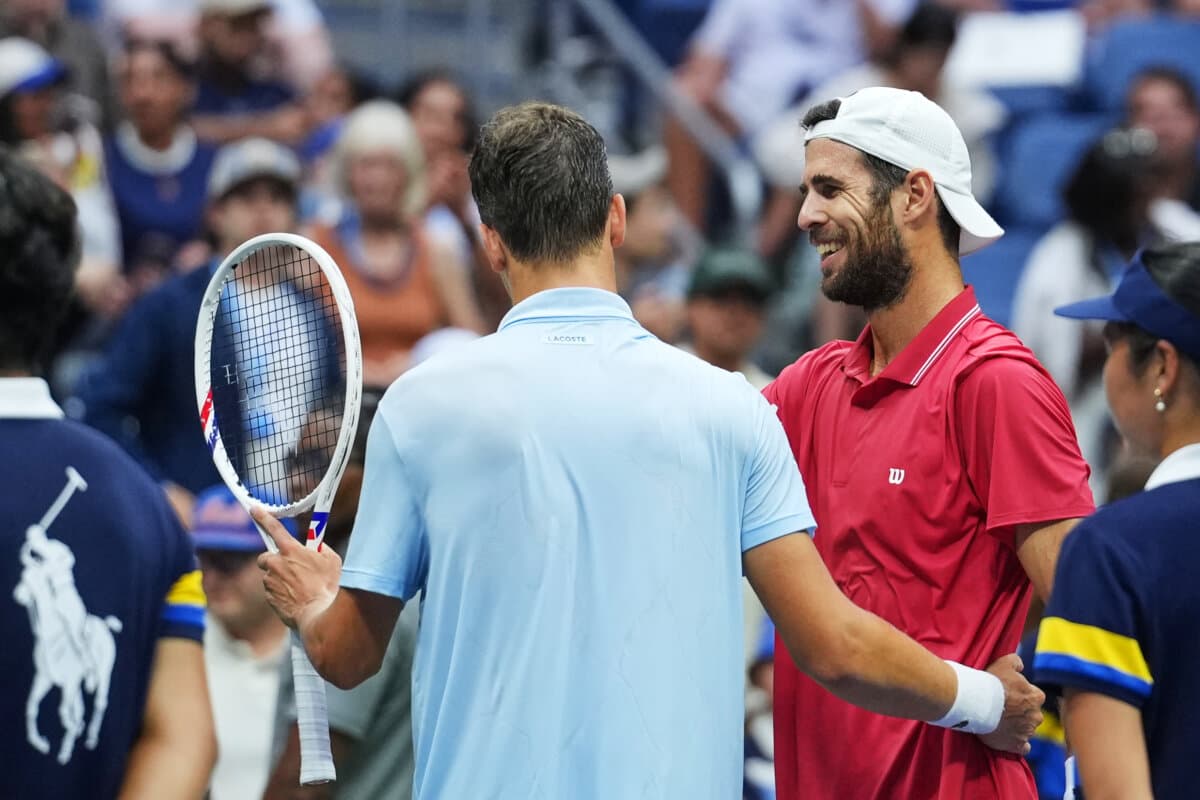 Alexander Blockx of Belgium (L) meets Karen Khachanov of Russia at the net after Blockx was forced to retire due to an apparent injury during the quarterfinal round of the U.S. Open tennis championships in New York on Sept. 9, 2026. (Kirsty Wigglesworth/AP Photo)