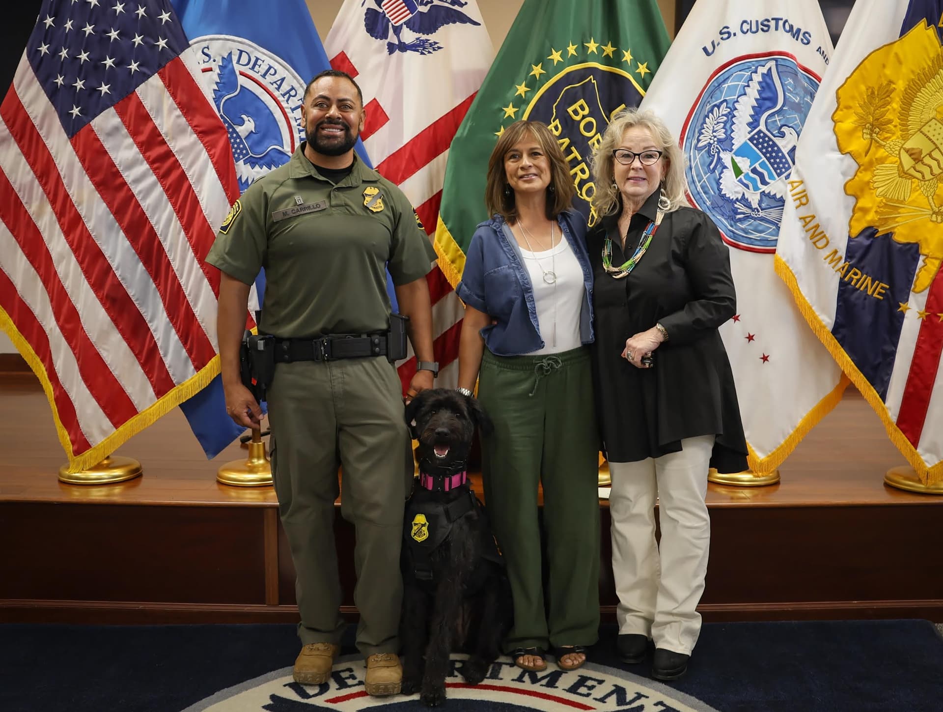 From left, Border Patrol Agent Miguel Carrillo, Chloe, and Lety Medrano and Loretta Hyde of the Animal Rescue League of El Paso at Chloe’s swearing-in ceremony at the Border Patrol Canine Academy in El Paso, Texas, on May 15, 2026. (Courtesy of CBP)