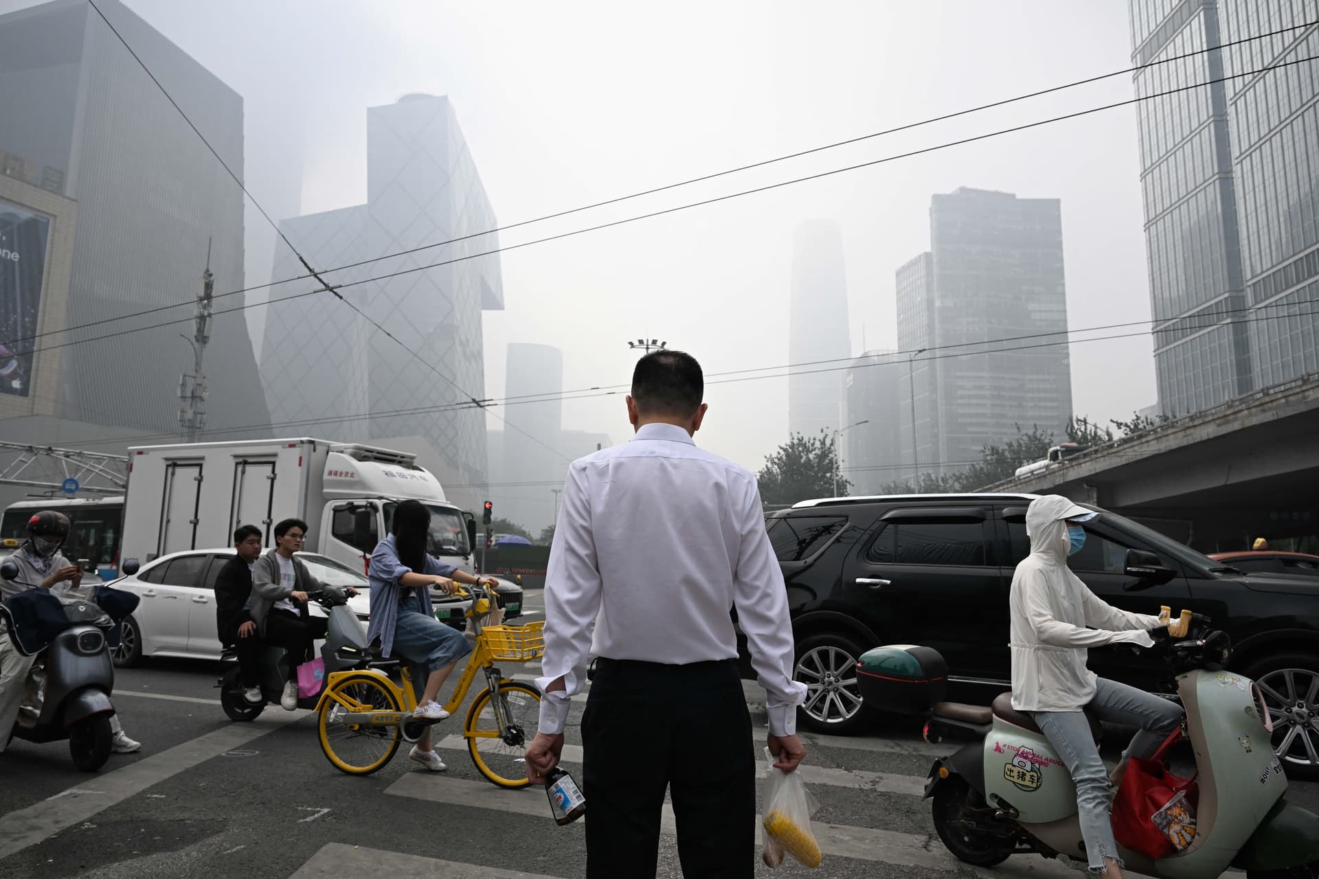 A man waits to cross a road during a high-pollution day in Beijing on Sept. 17, 2026. (Greg Baker/AFP via Getty Images)