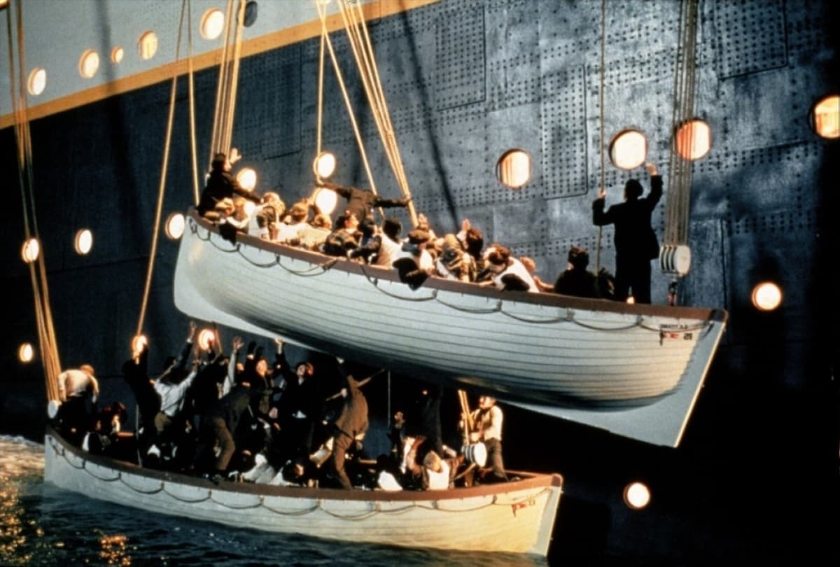 Lifeboats filled with women and children are being lowered, in “Titanic.” (Paramount Pictures)