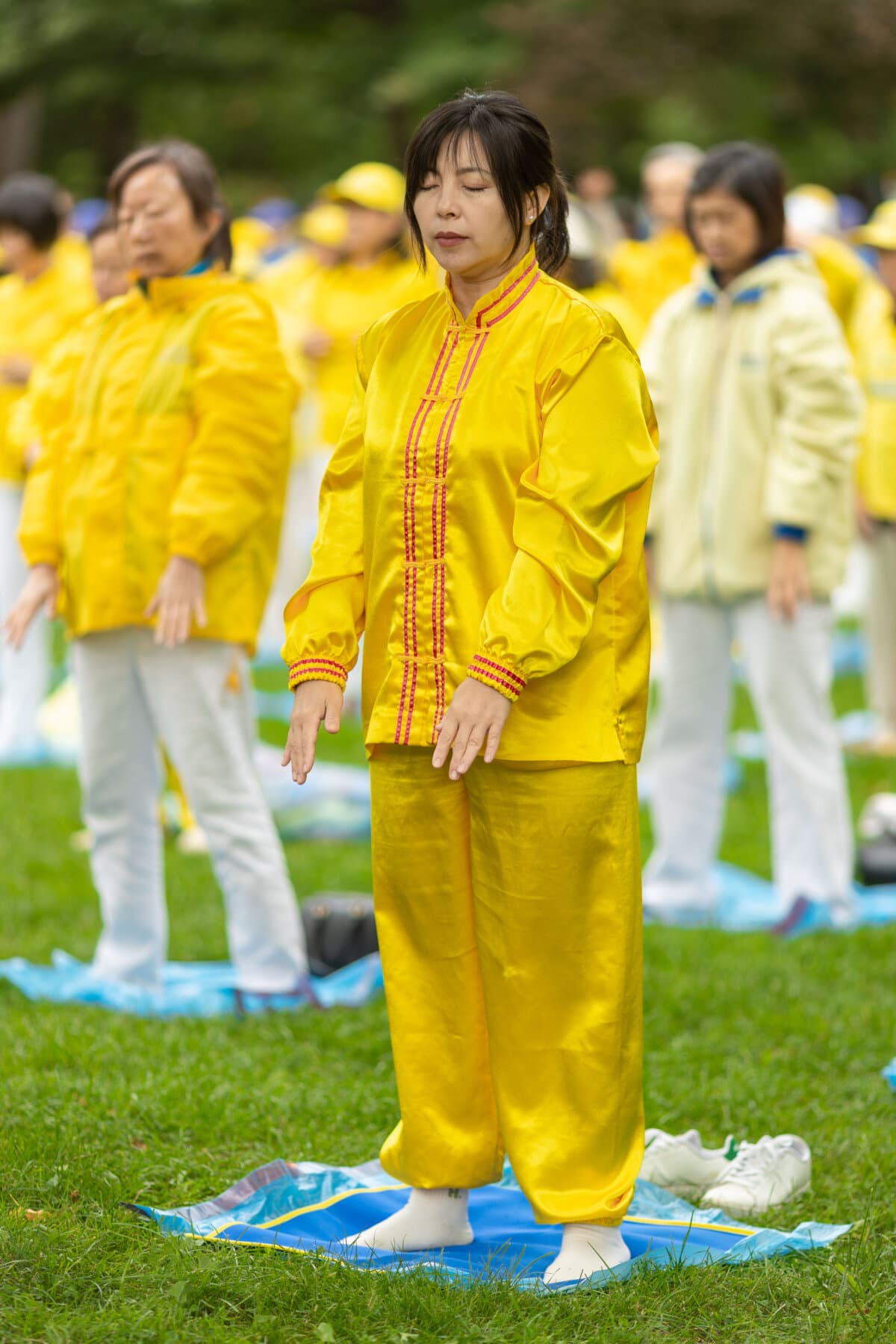 Falun Gong practitioners perform the spiritual discipline's meditative exercises at an event at Queen's Park, to call for an end to the Chinese regime's persecution and transnational repression, in Toronto on Sept. 19, 2026. (Alex Gurevich)