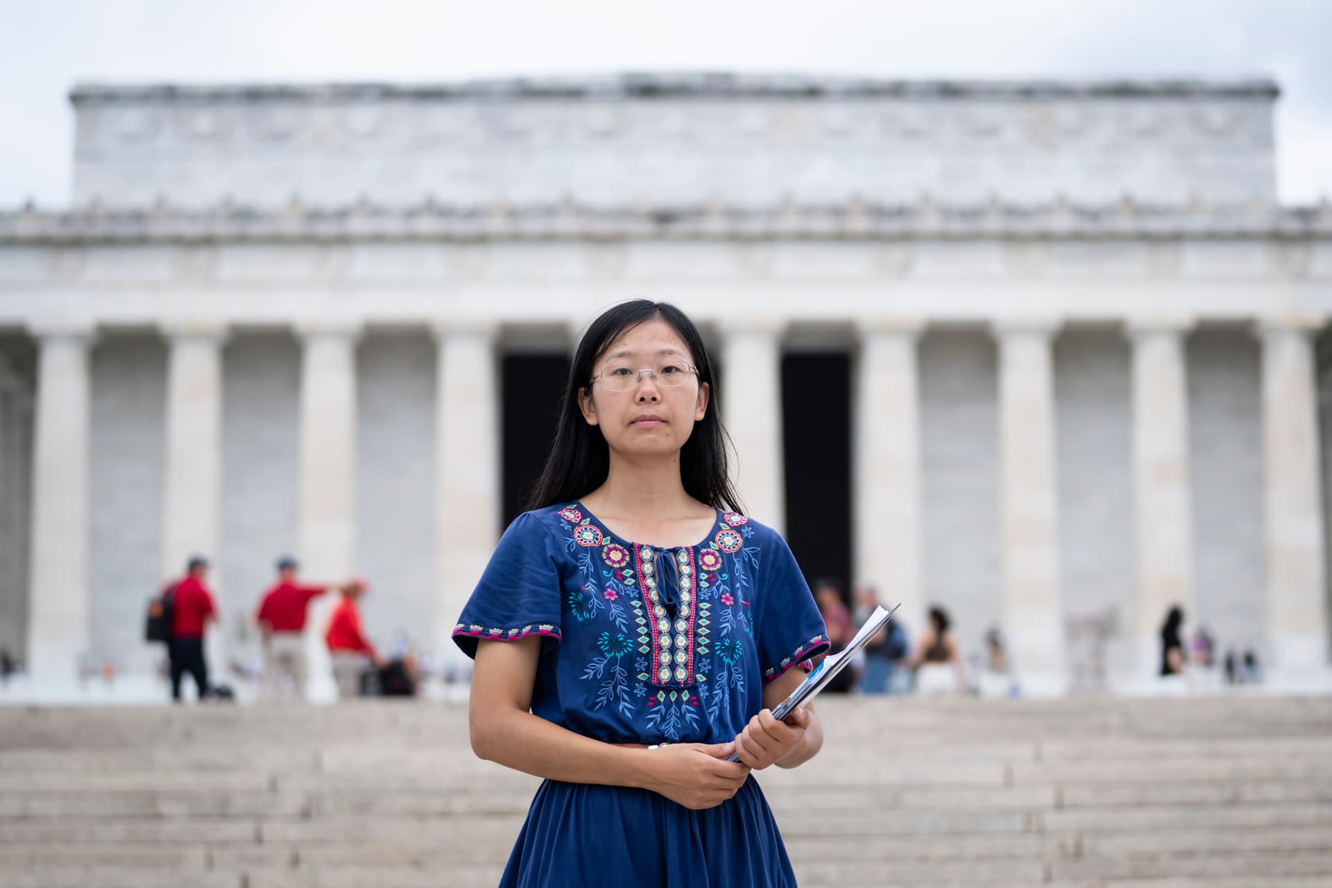 Falun Gong practitioner Alisa Zhou passes out flyers raising awareness about the Chinese Communist Party's ongoing persecution of her faith in China at the Lincoln Memorial in Washington on Sept. 19, 2026. Zhou’s mother Wang Youmei has been detained since April in Wuhan, China, because of her faith. (Madalina Kilroy/The Epoch Times)