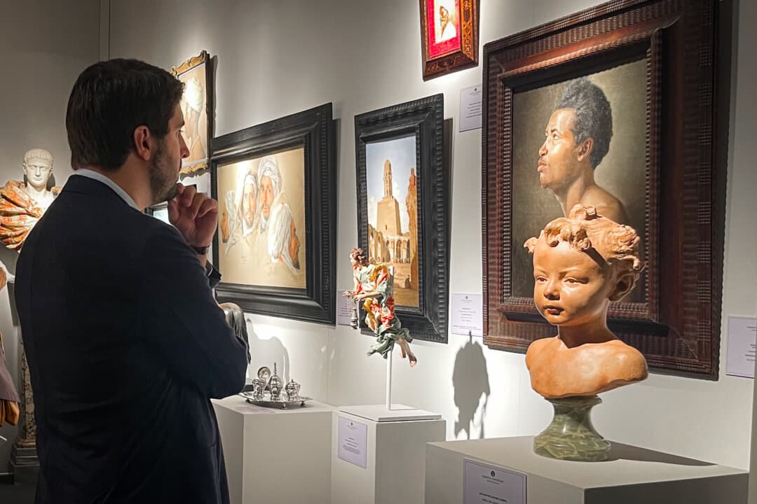 A visitor ponders works on display at the stall of Roberto Campobasso, a Naples gallerist, at the 34th International Biennial of Antiques in Florence, Italy, on Sept. 25, 2026. (Beige Luciano-Adams/The Epoch Times)