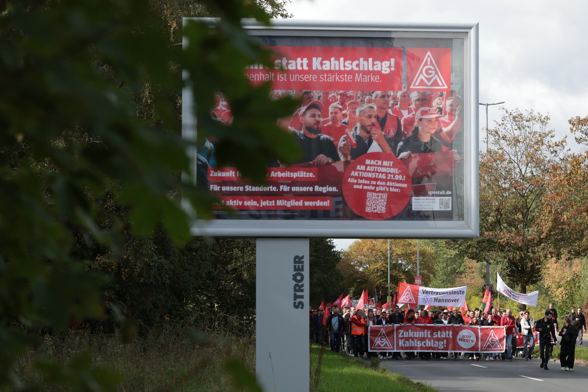 Demonstrators hold a banner reading "A Future Instead of Clear-Cutting" as they protest against job cuts in front of the commercial car plant of German carmaker Volkswagen (VW) in Hanover, Germany, on Sept. 21, 2026. (Ronny Hartmann/AFP via Getty Images)