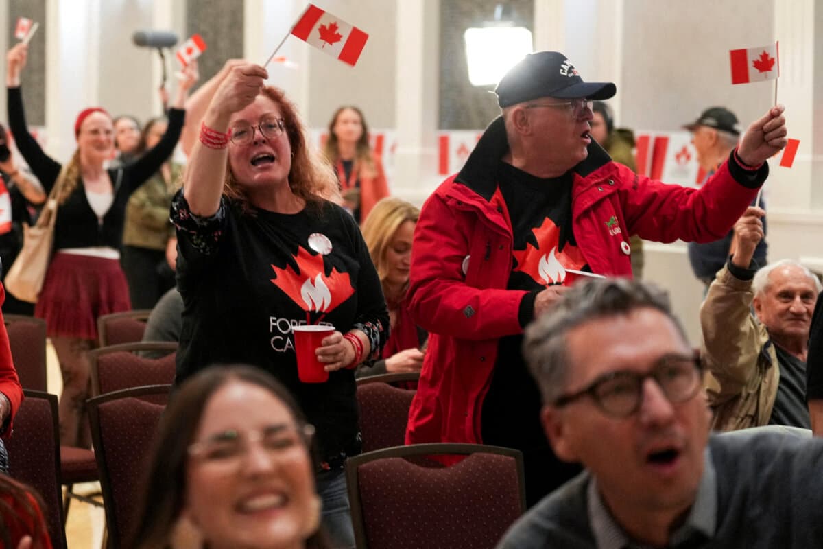Supporters of the Forever Canadian group, who want Alberta to remain in Canada, wave Canadian flags as they watch the results of a non-binding referendum on Alberta sovereignty, in Edmonton on Oct. 19, 2026. (Reuters/Todd Korol)