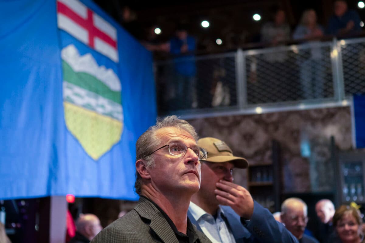 Alberta Prosperity Project supporters watch the referendum results start to appear in Edmonton, on Oct. 19, 2026. (The Canadian Press/John Ulan)
