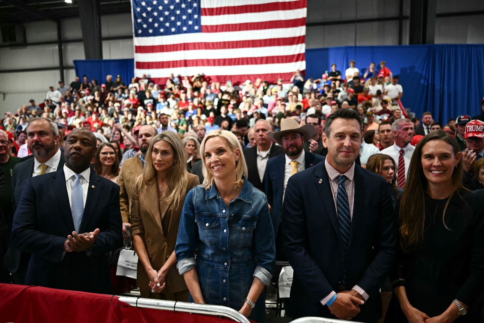 (L-R) U.S. Sen. Tim Scott (R-S.C.); his wife, Mindy Noce; Republican U.S. Senate candidate Ashley Hinson; Republican gubernatorial candidate Zach Lahn; and his wife, Annie Lahn, listen as U.S. President Donald Trump speaks at a midterm election campaign rally at Sioux Gateway Airport in Sioux City, Iowa, on Oct. 22, 2026. (Kent Nishimura/AFP via Getty Images)