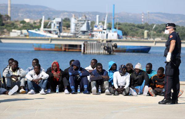 People wait to be checked after disembarking from the Italian Coast Guard vessel Peluso as they arrive in the Sicilian port town of Augusta, Italy, on June 3, 2015. (AP Photo/Francesco Malavolta)