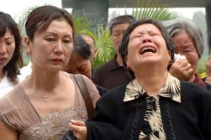 People commemorating victims of the 1976 Tangshan earthquake at the memorial wall. (The Epoch Times)