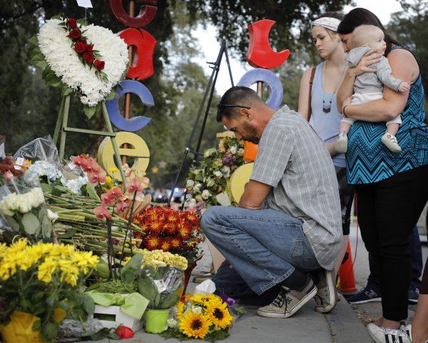 Jason Coffman, father of slain victim Cody Coffman, kneels at his son's vigil with his pregnant wife, Shari, Cody's stepmom, and close friend Jessie and her son Alijah in Westlake Village, Calif., on Nov. 15, 2018. (Barbara Davidson/Getty Images)