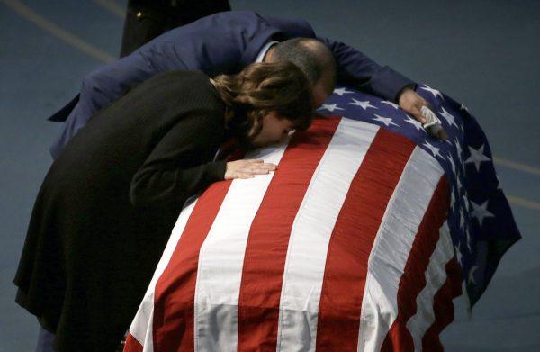 Lupe Corona and Merced Corona kiss the flag draped coffin of their daughter, Davis Police Officer Natalie Corona, during funeral services for Natalie Corona at the University of California, Davis, in Davis, Calif., on Jan. 18, 2019. (Rich Pedroncelli, Pool/AP)