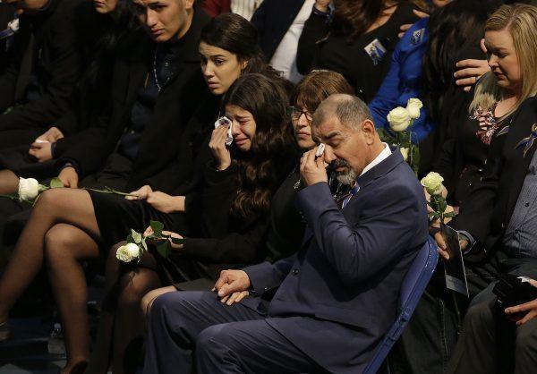 Merced Corona, father of Davis Police Officer Natalie Corona, foreground, and family members wipe their eyes as they listen to speakers during funeral services for Natalie Corona at the University of California, Davis in Davis, Calif., on Jan. 18, 2019. (Rich Pedroncelli, Pool/AP)