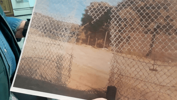 Bob Maupin holds a photo of a hole in his fence cut in the shape of an "M", for MS-13. (Courtesy of Robert (Bob) Maupin.